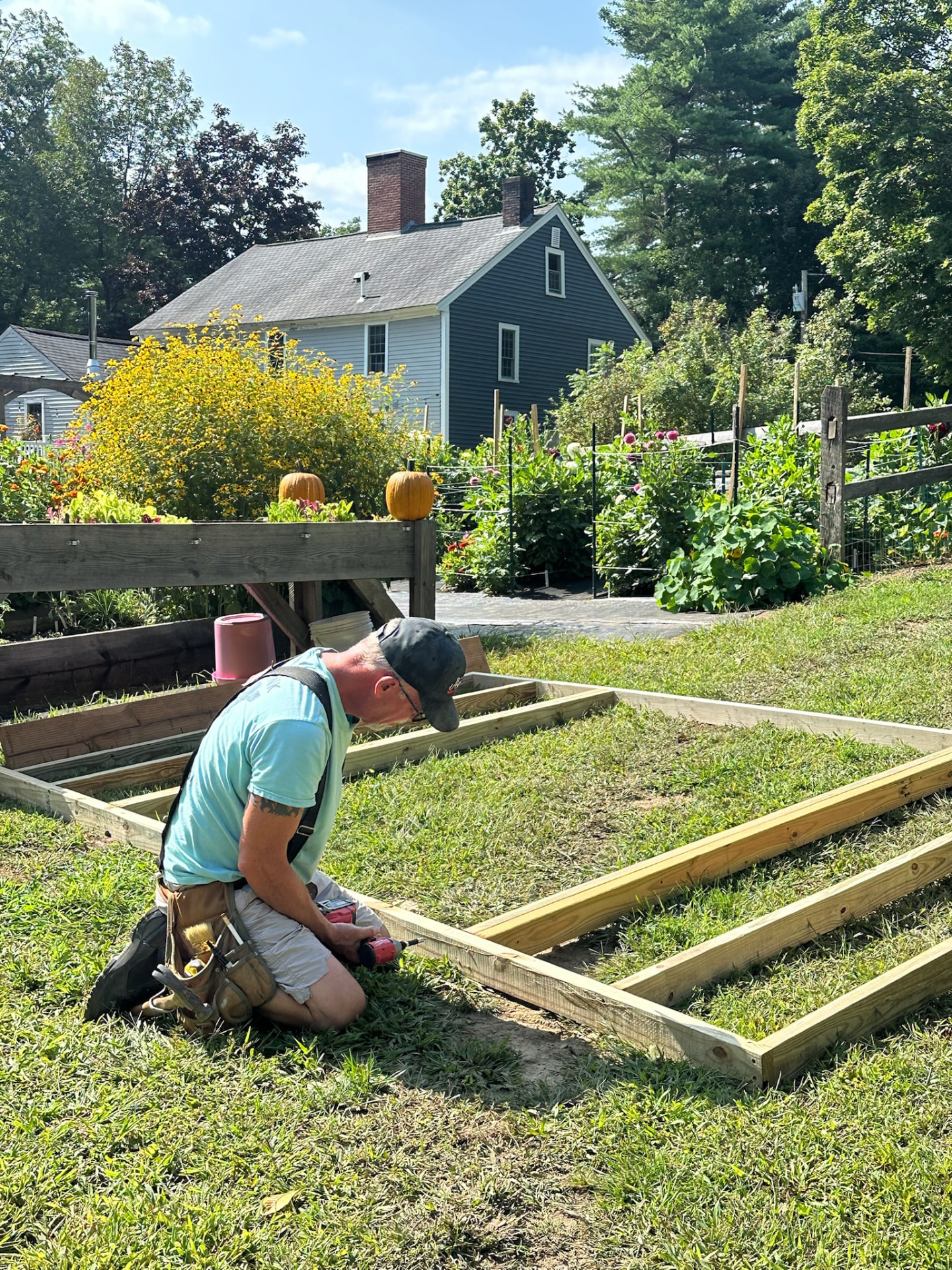 Tommy building raised garden beds at Honey & Bloom Barn